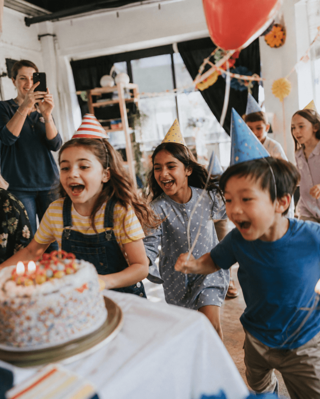 Children rushing toward a birthday cake