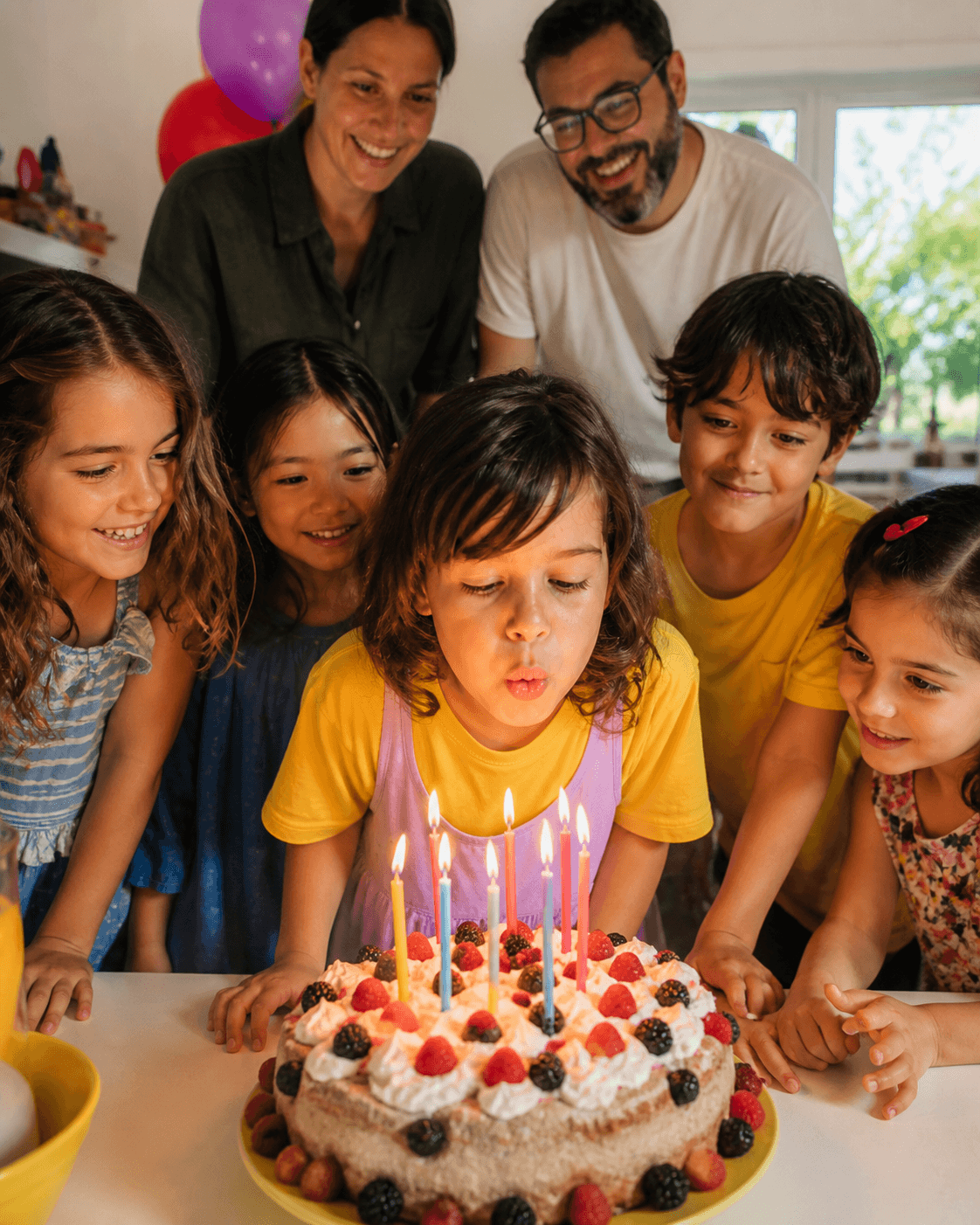 Birthday child blowing out candles with friends